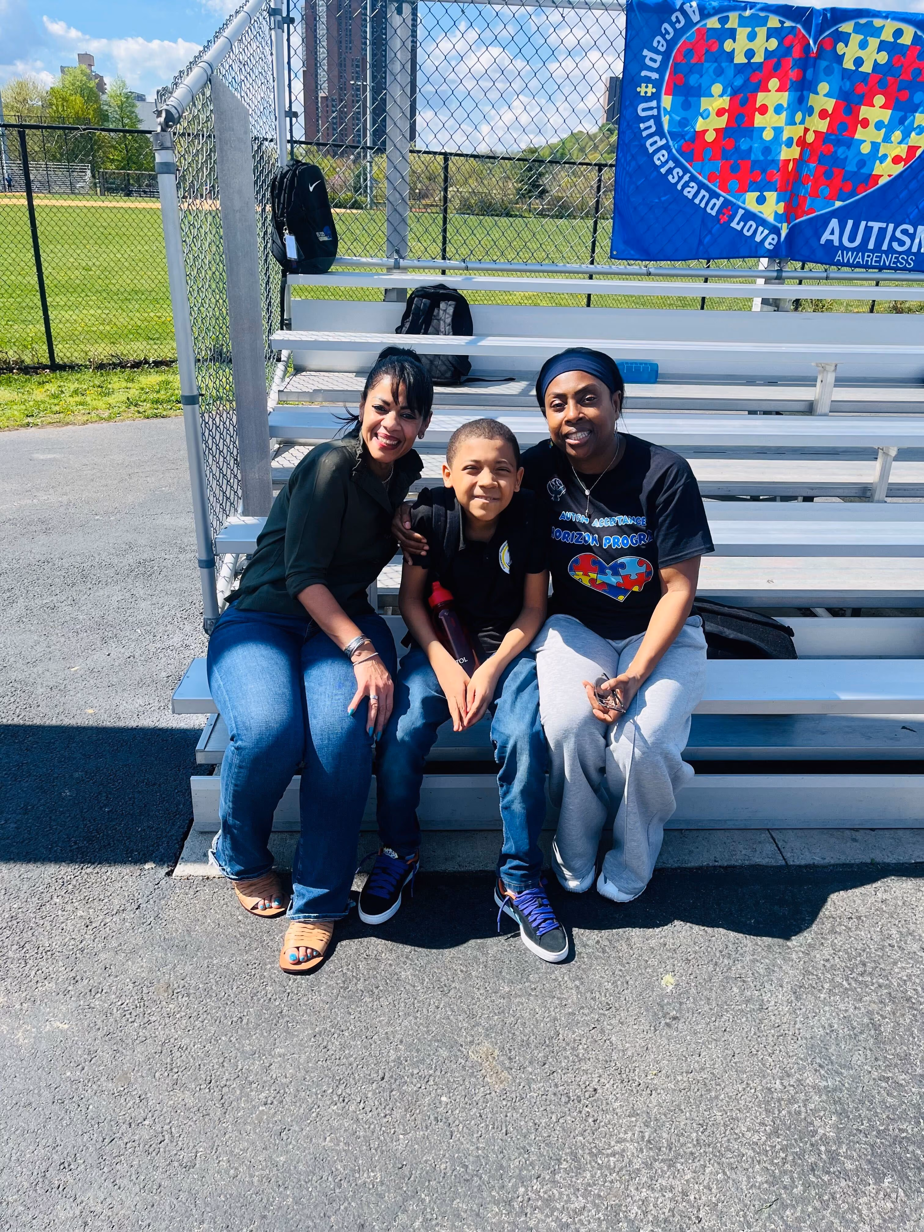 Two adults and a child at an Autism Awareness outdoor event