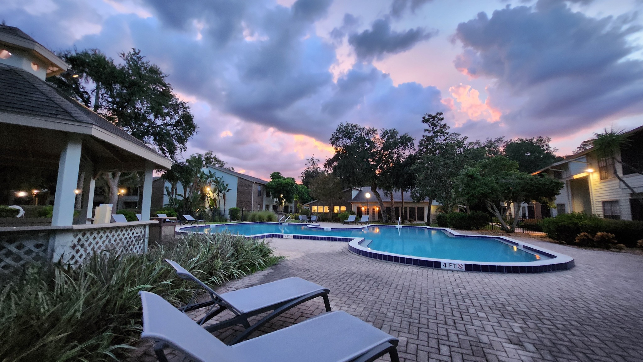 Swimming pool with lounge chairs a sunset