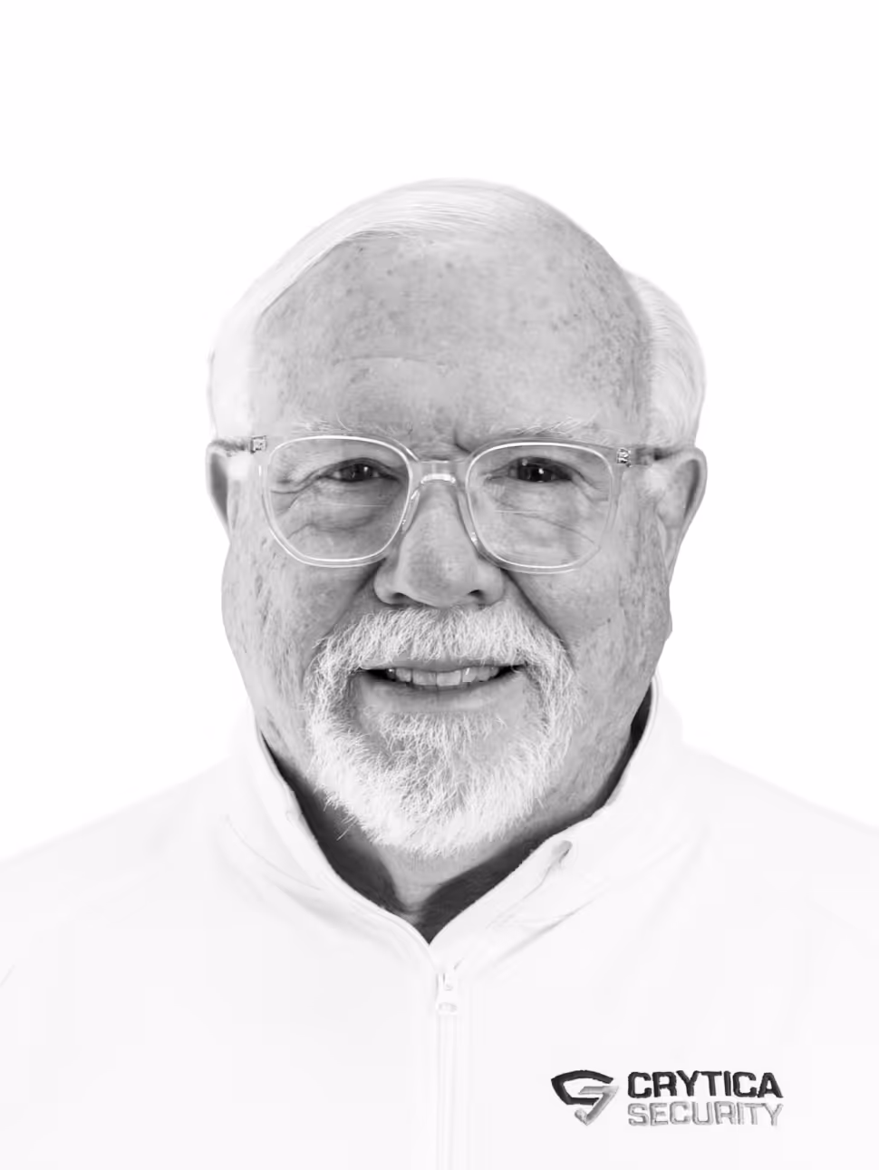 Smiling elderly man with white hair, beard, and glasses wearing a patterned dark shirt.