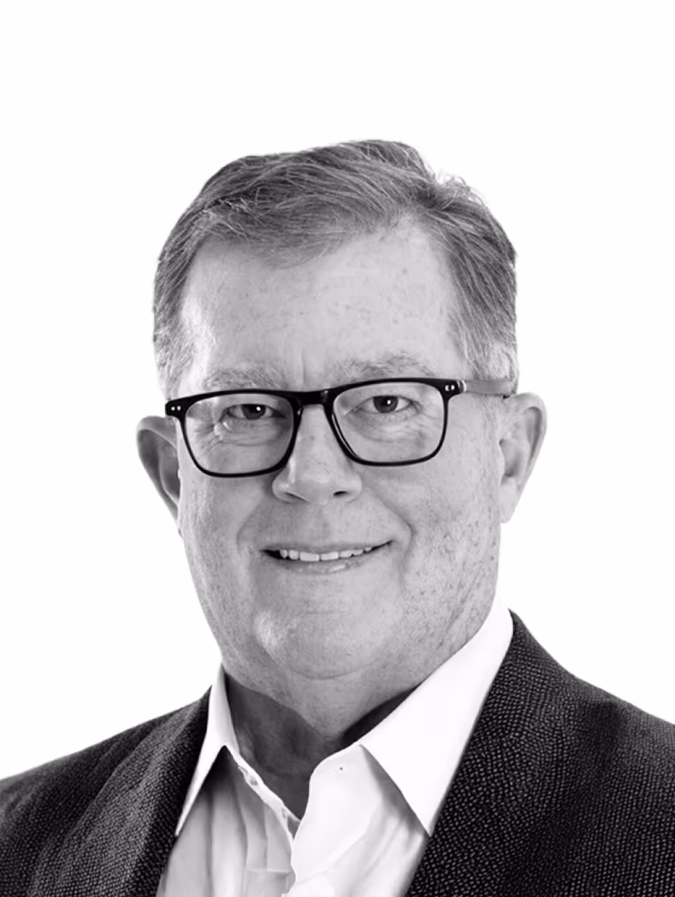Portrait of a middle-aged man with short hair, wearing glasses, a white shirt, and a dark blazer, smiling slightly.