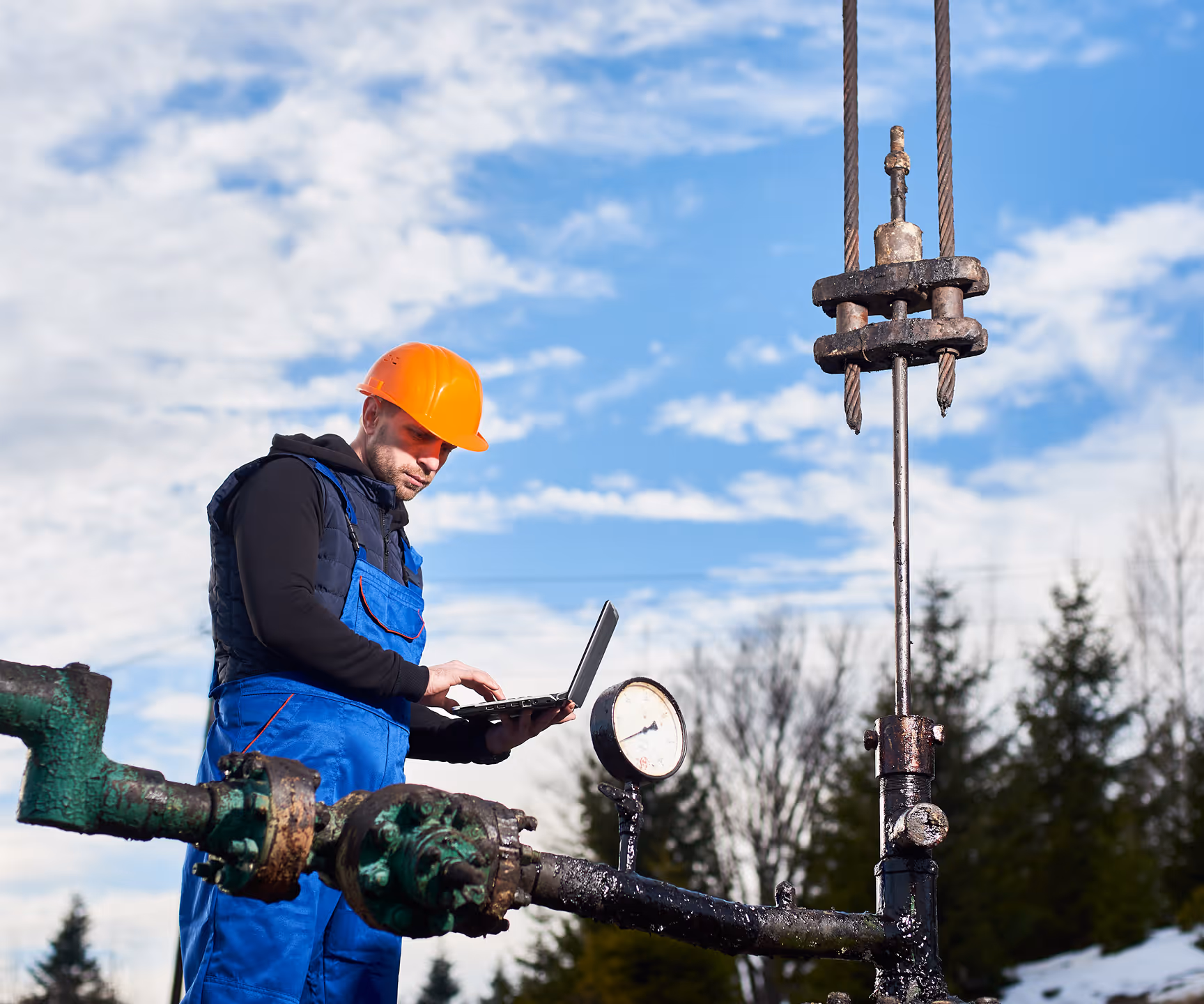 Technician monitoring pressure gauges at an oil extraction site.