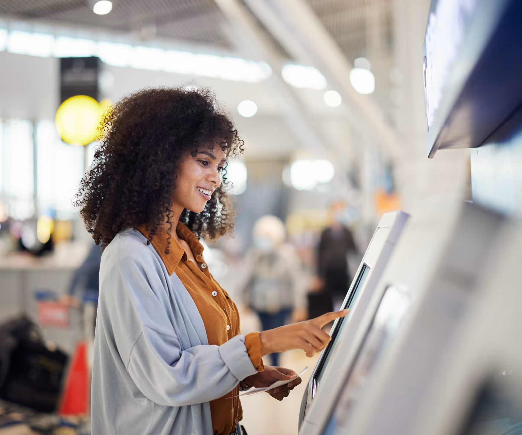 A woman using a self-service atm kiosk.