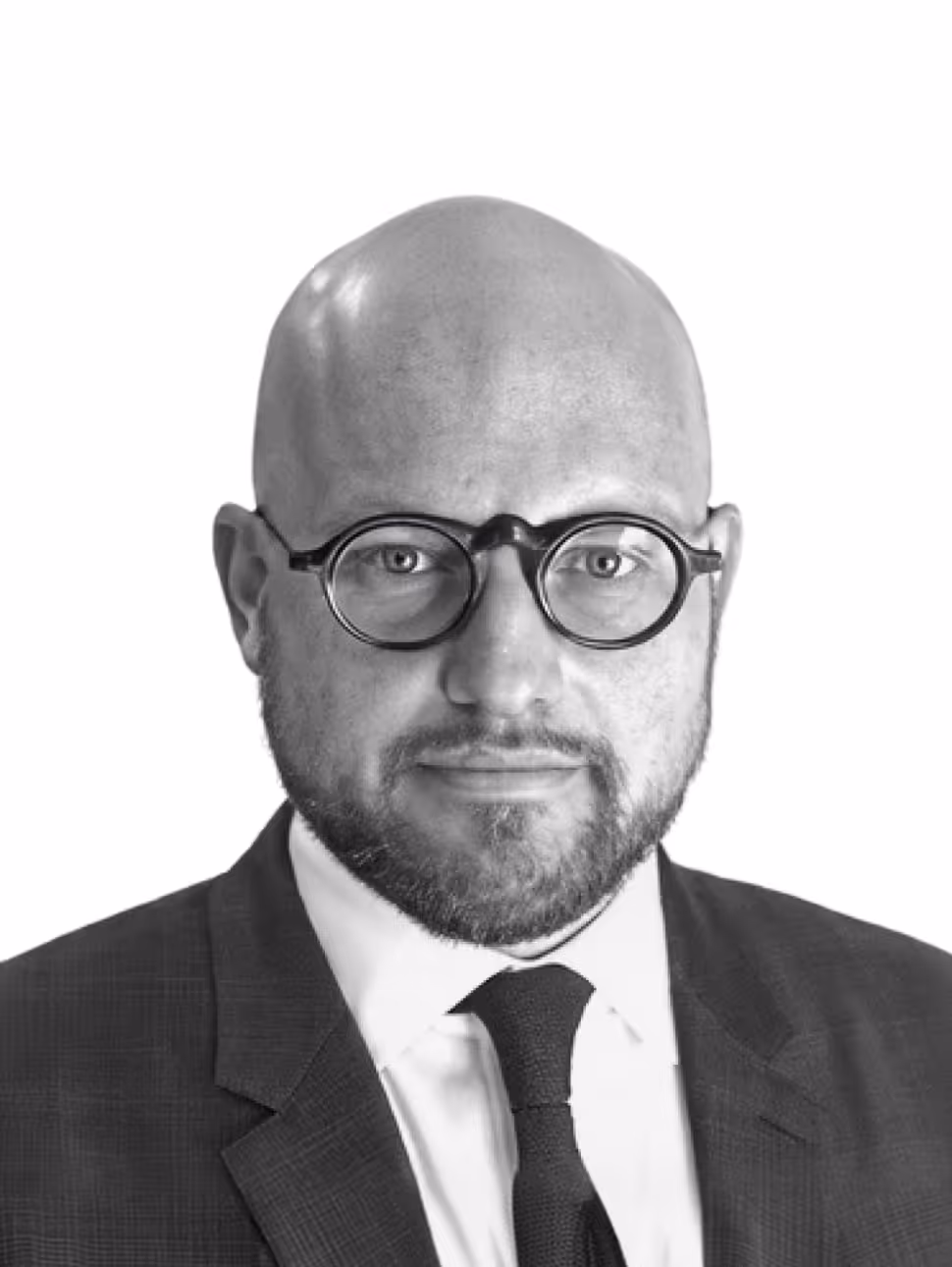 Portrait of a bald man with a beard wearing round glasses, a suit, white shirt, and dark tie.