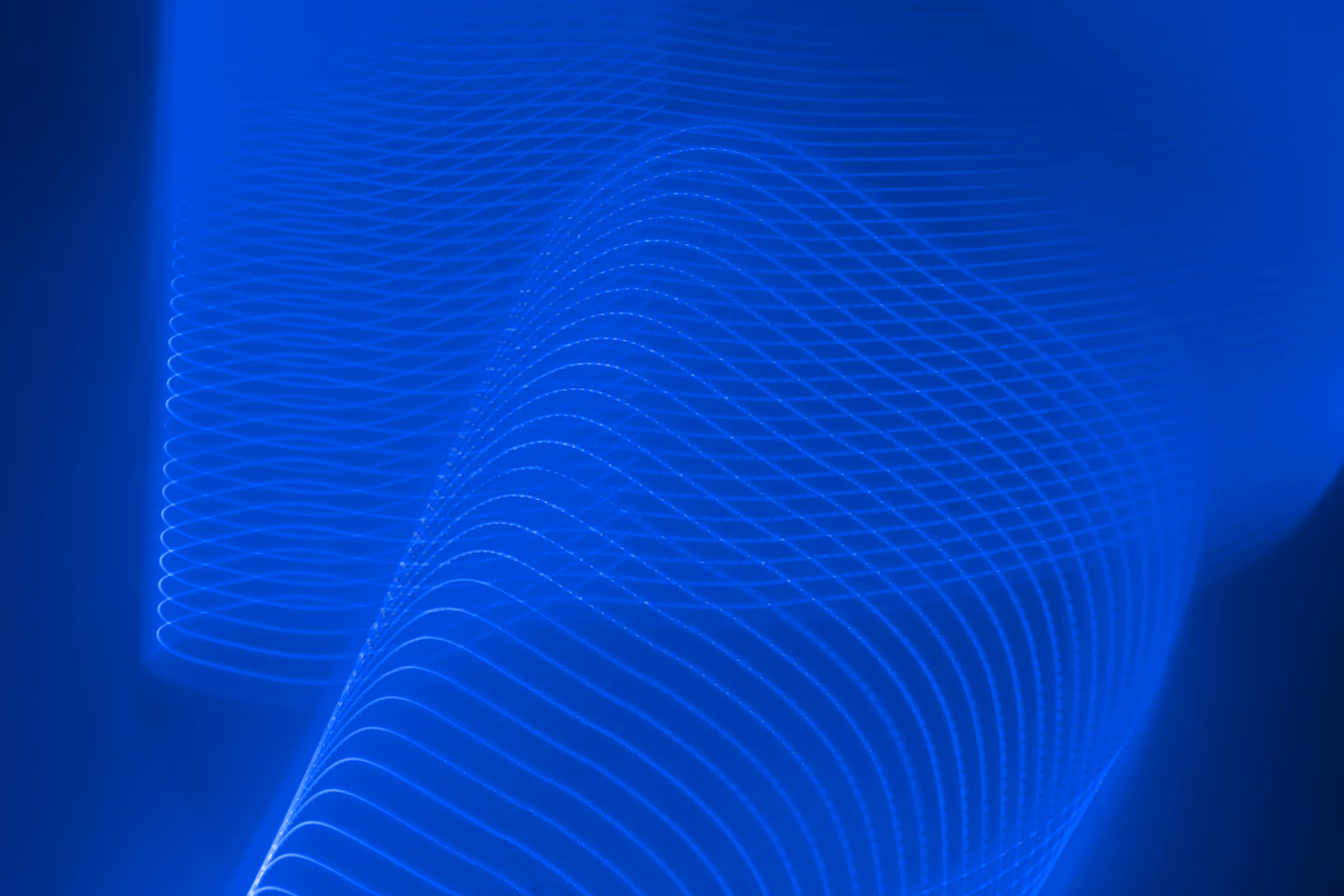A shiny white sphere with a subtle purple-blue gradient floating against a blue background with faint curved grid lines.