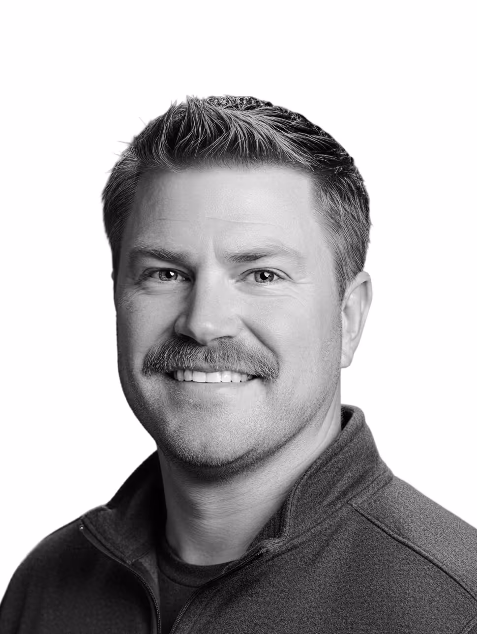Smiling man with short hair and mustache wearing a zip-up jacket against a white background.
