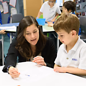 teacher providing individual instruction to a young male student
