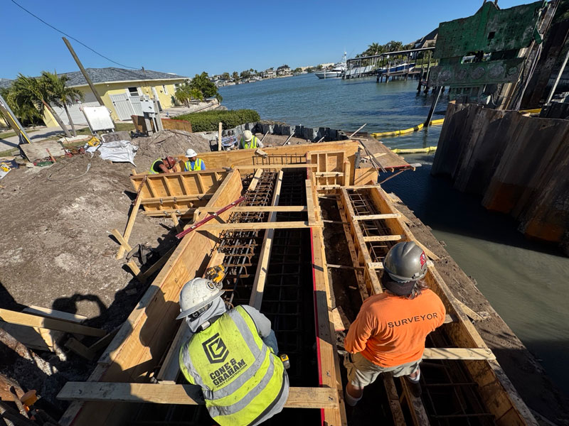 Davris surveyor overseeing waterfront construction layout and foundation work along a Florida seawall project.