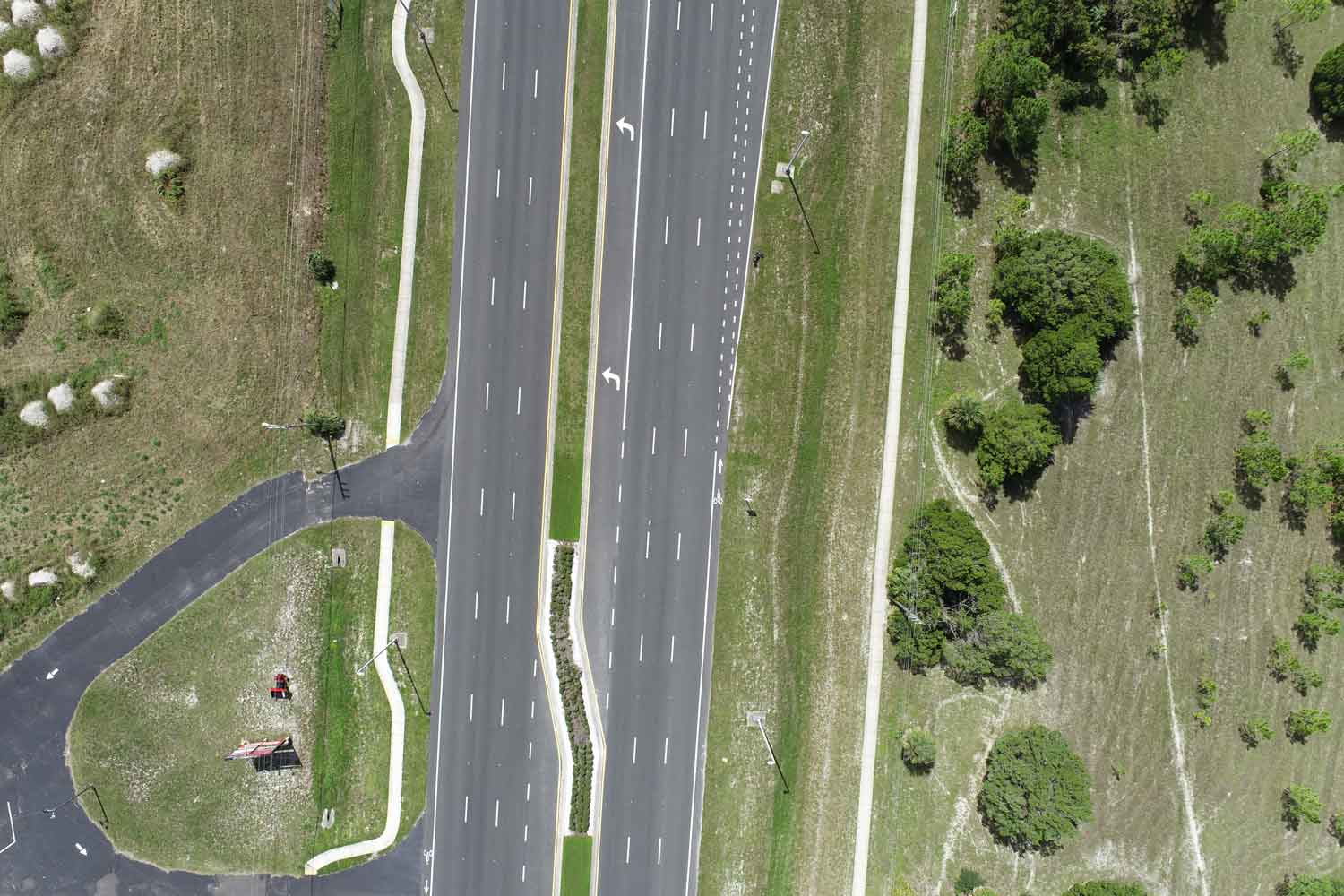 Aerial view of an industrial waterfront property with gravel roads, open land, equipment storage, and coastal site access.