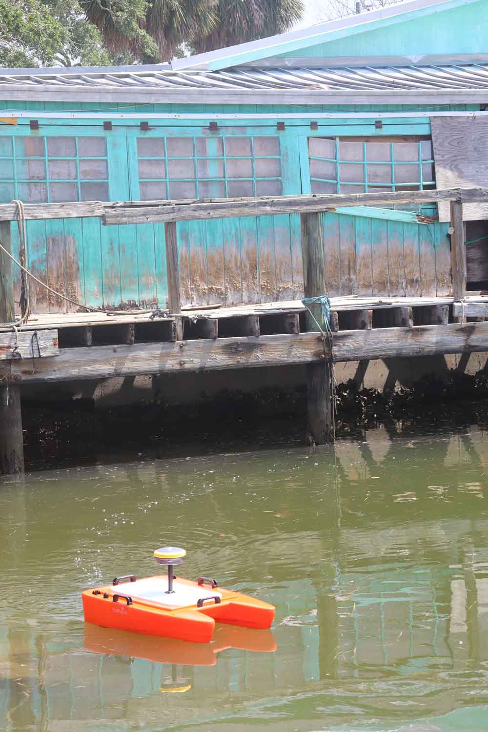 Surveying equipment is operating along a body of water.