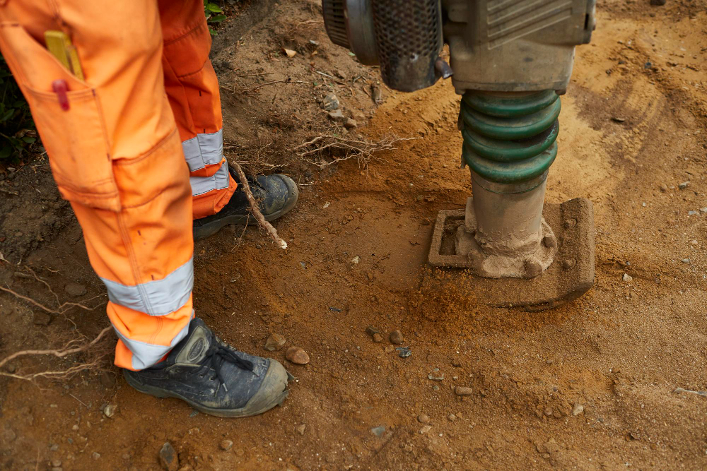 Woman with blonde hair in a striped shirt sitting at a white desk, holding a pen and looking to the side with a laptop and mug nearby.