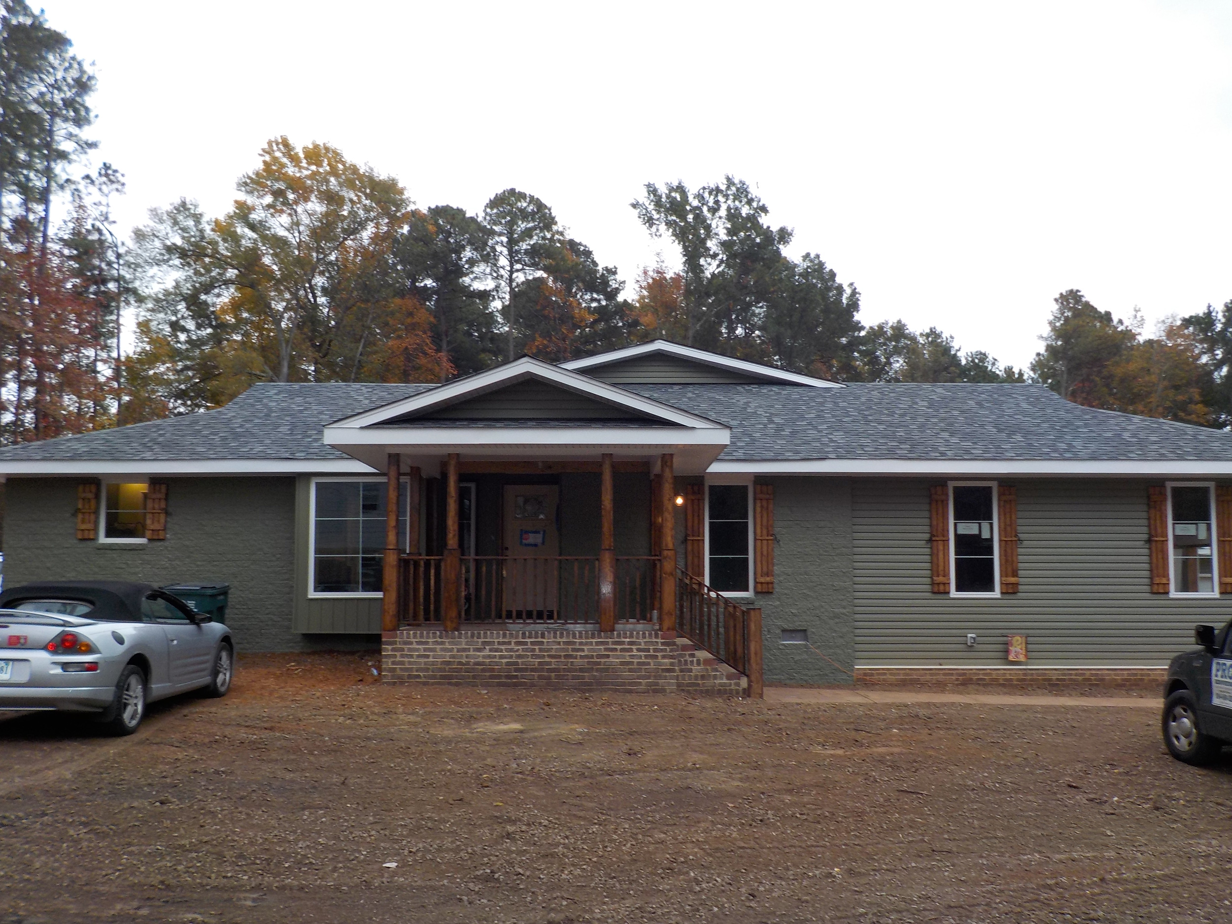 Covered wooden porch extending across the front of a single-story home.