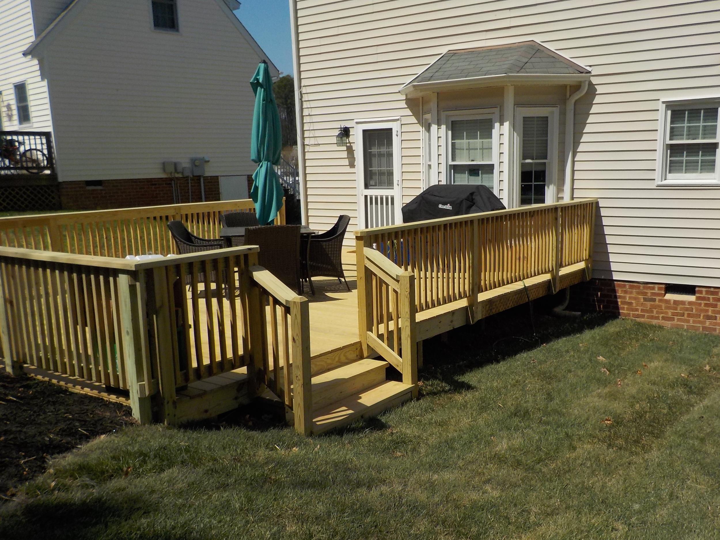 Wooden accessibility ramp with railings and adjacent steps leading to the home.