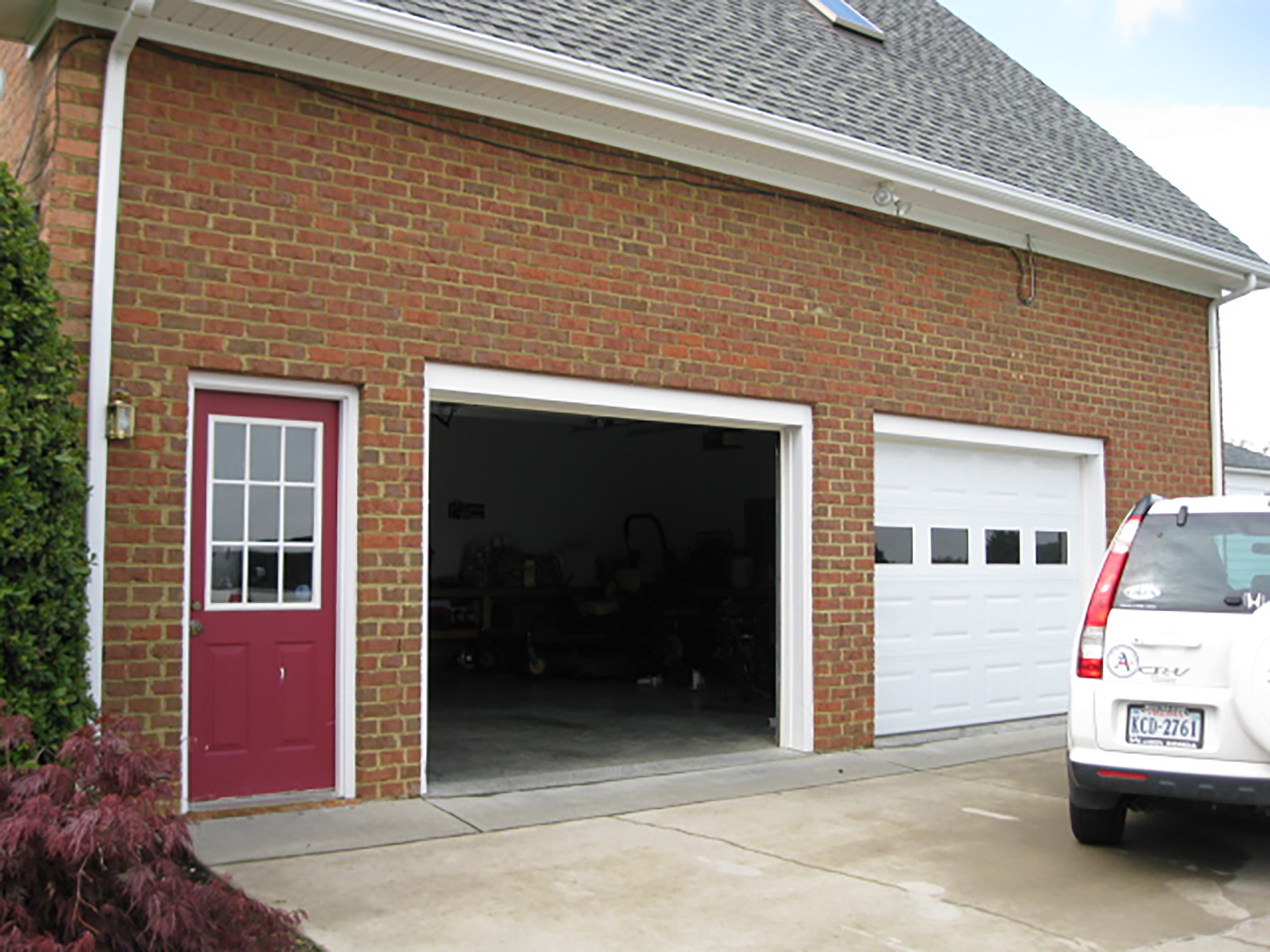 Brick two-car garage with a side entrance and contrasting red door.