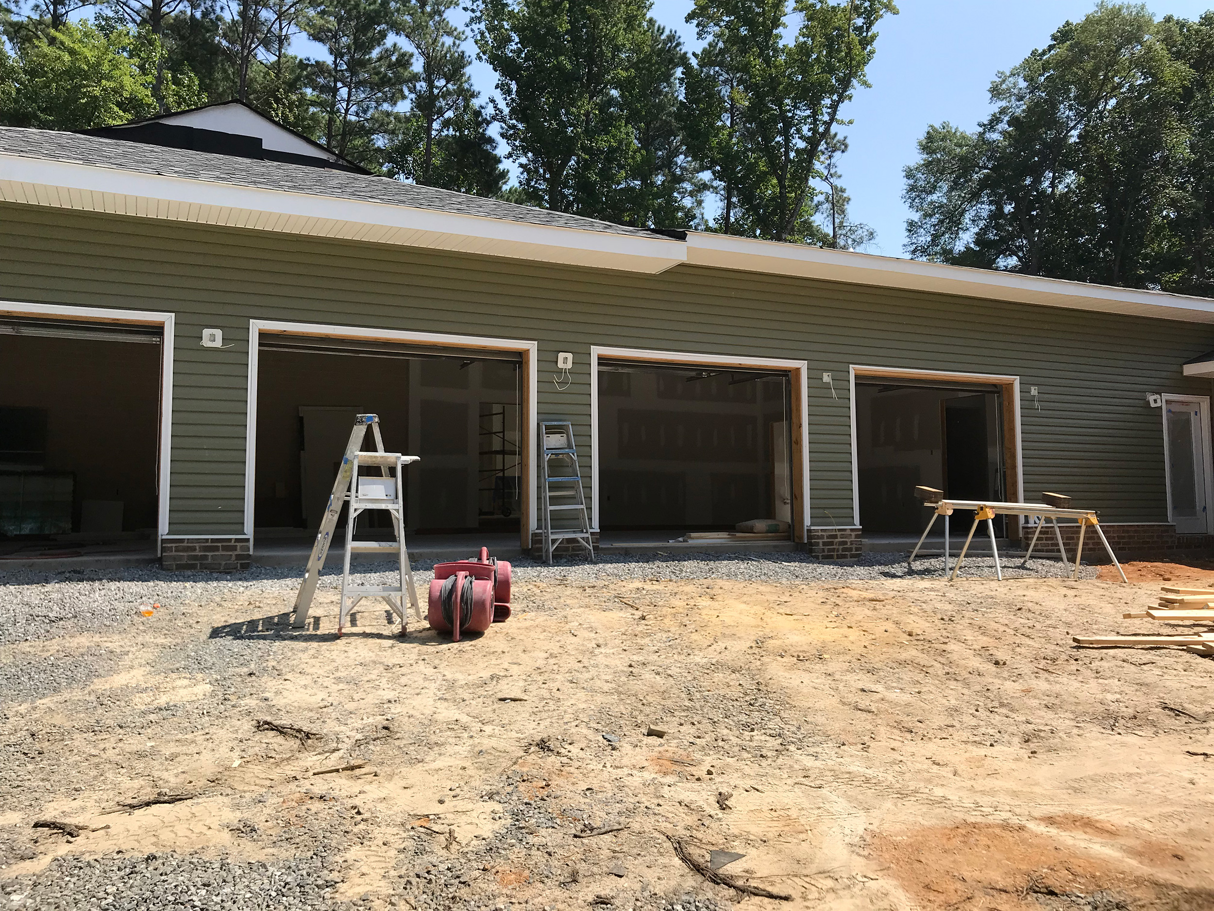 Detached three-bay garage under construction with gray siding.