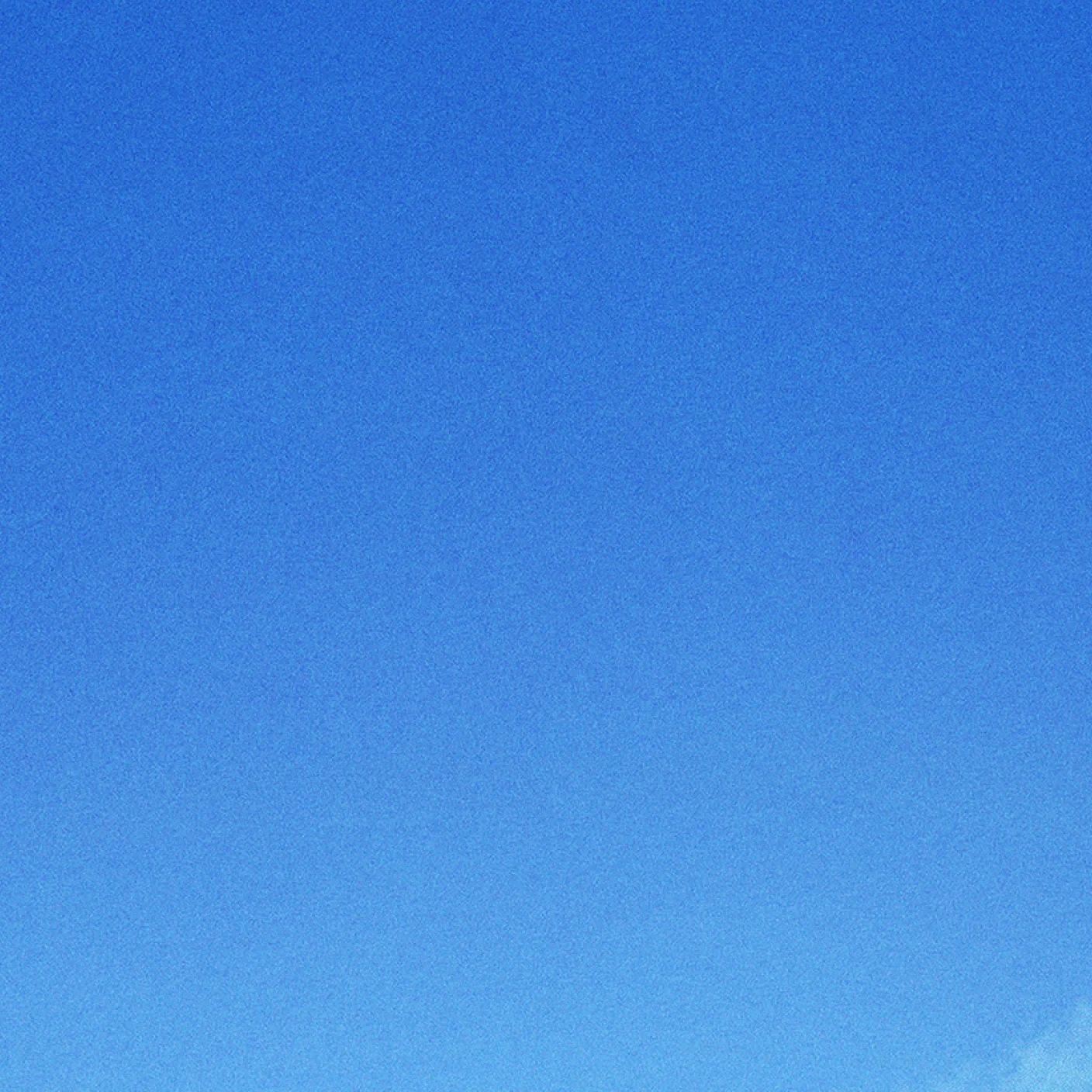 Clear blue sky with a gradient from deeper to lighter blue.