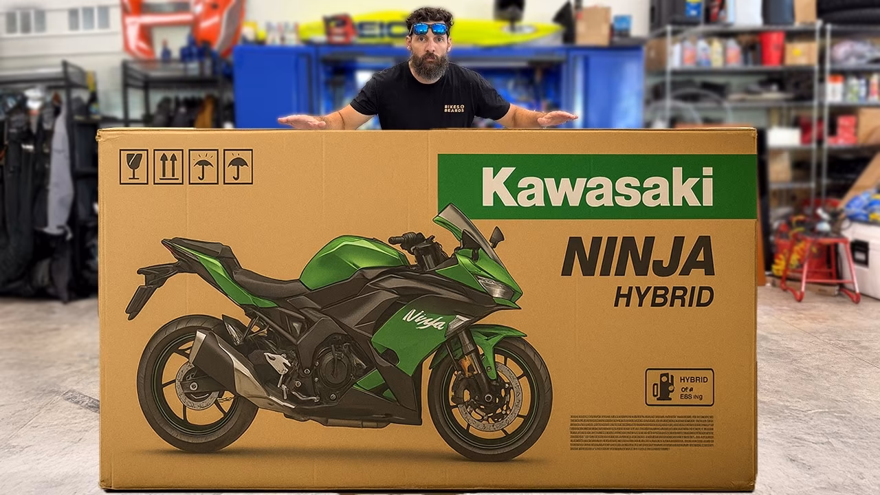 Man standing behind a large cardboard box featuring an image of a green Kawasaki Ninja Hybrid motorcycle.
