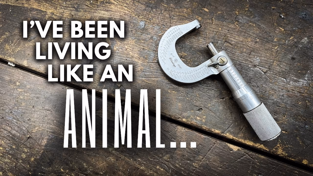 A metal micrometer on a scratched wooden surface next to white text saying 'I'VE BEEN LIVING LIKE AN ANIMAL...'.