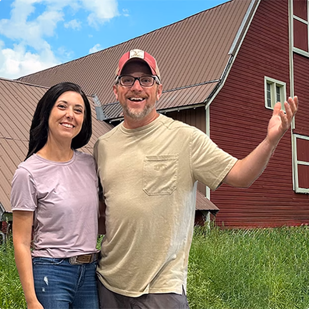 Smiling middle-aged man wearing a dark coat in a warmly lit indoor setting.
