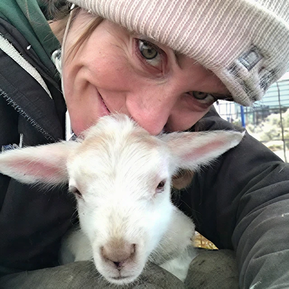 Smiling middle-aged man wearing a dark coat in a warmly lit indoor setting.