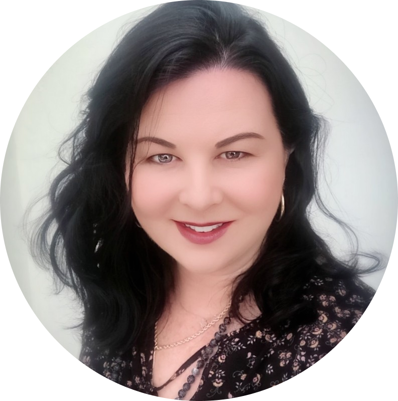 Smiling woman with long black hair, wearing a floral top, necklace, and hoop earrings.