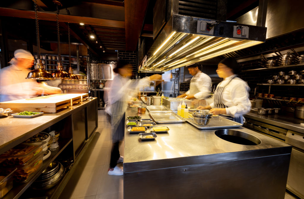 Chefs plating on a busy restaurant expo line during service