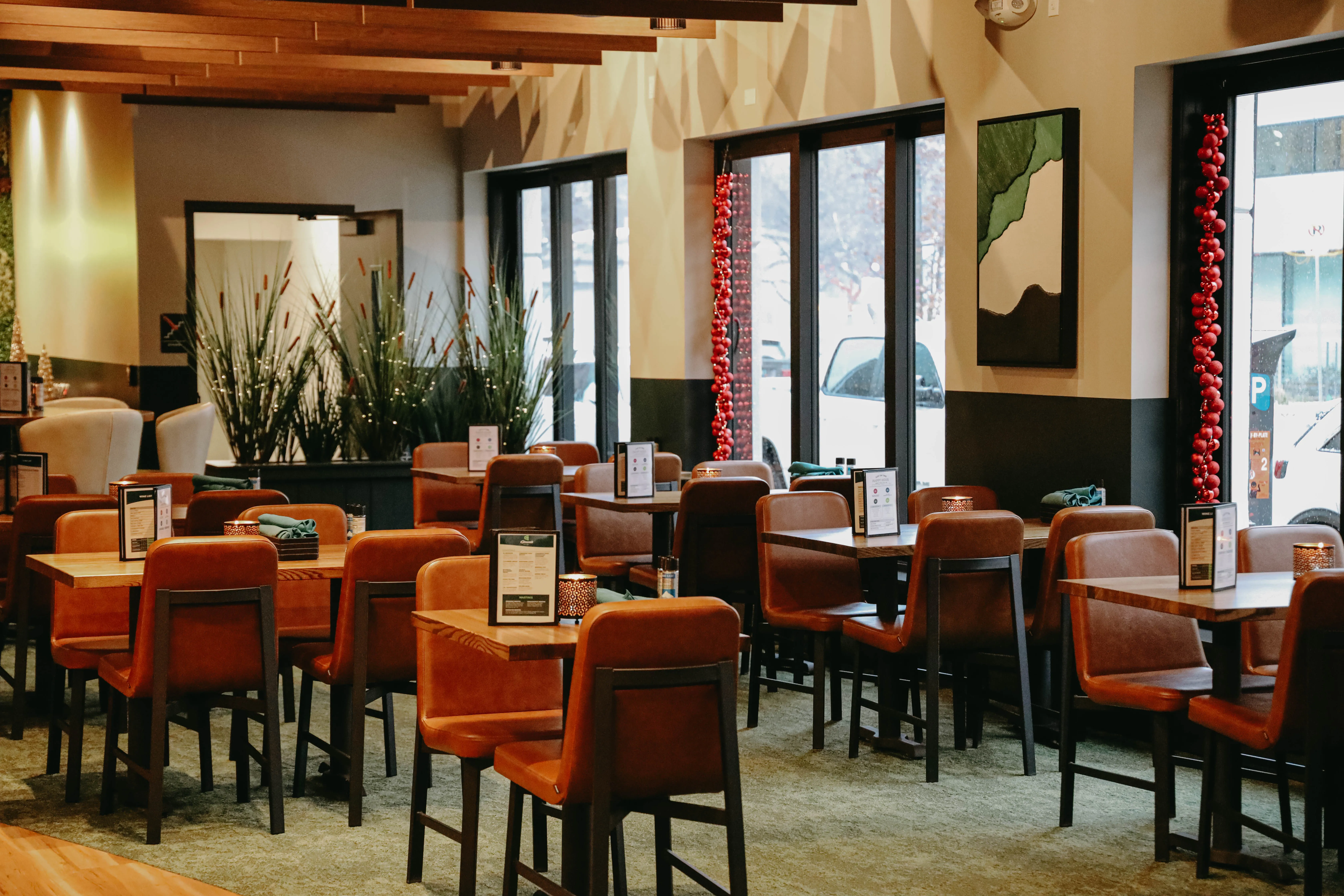 Warm, upscale restaurant dining room with pendant lighting and natural light