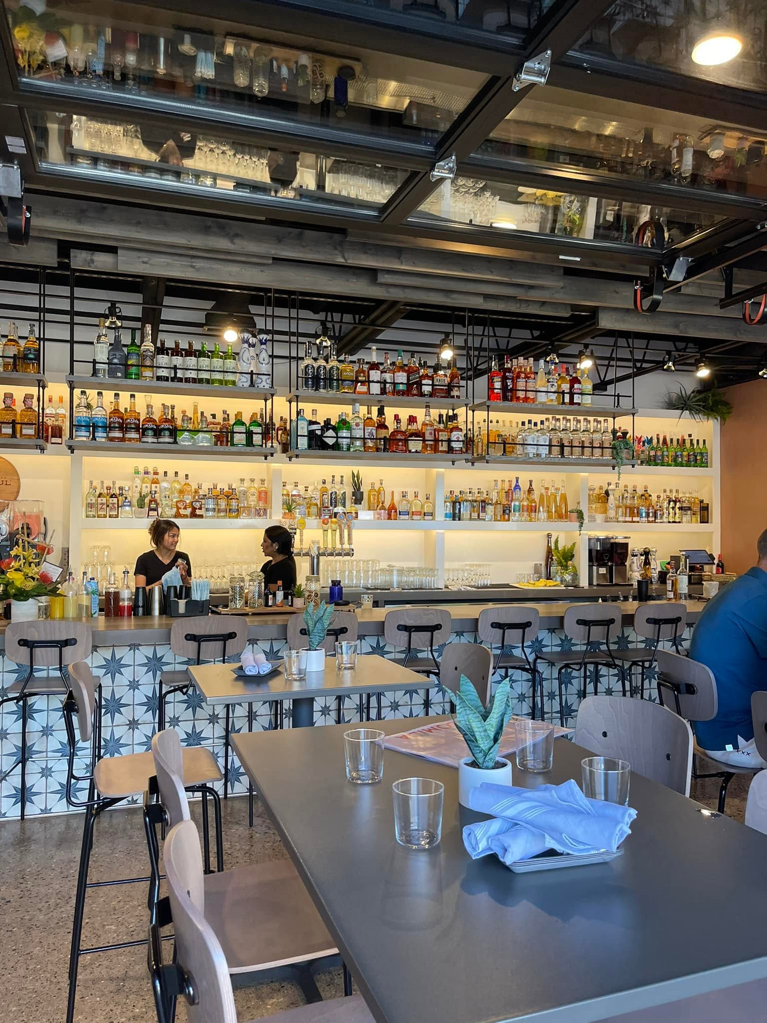 Bartenders finishing a craft cocktail at a well-stocked bar