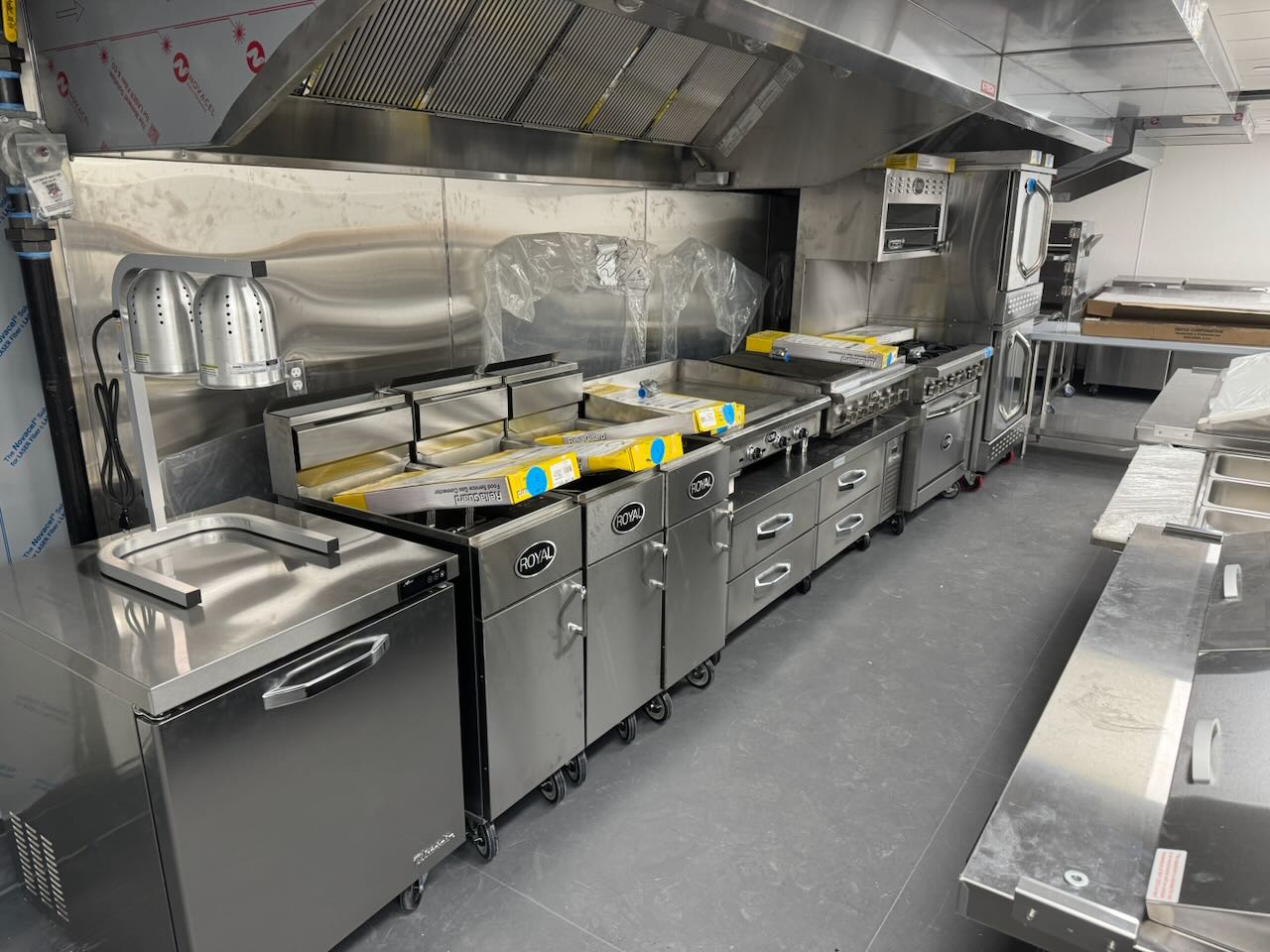 Commercial kitchen equipment installation in progress during a restaurant construction project, representing new-build project oversight and development coordination.