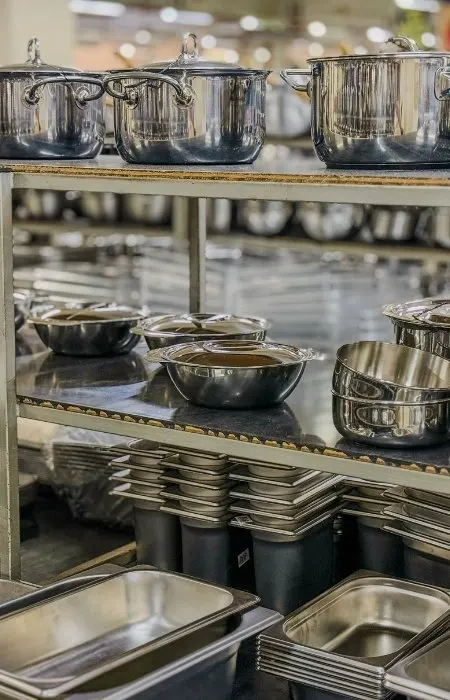 Restaurant kitchen smallwares, pots, pans, and tray selections laid out for specification review.
