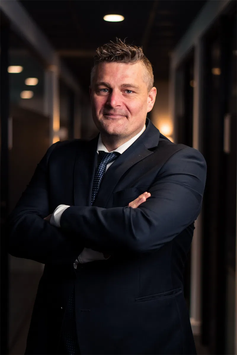 Fire af de mennesker der står bag Lorentzen & Partners, sidder og står foran væg med indrammede billeder.