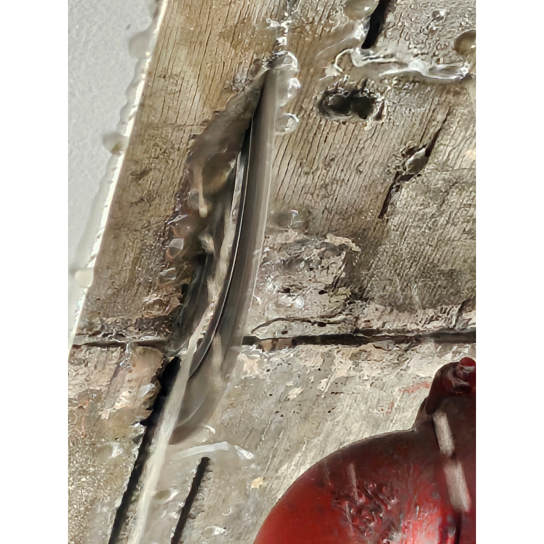 Close-up of damaged concrete ceiling with exposed rebar and a red pipe fixture.