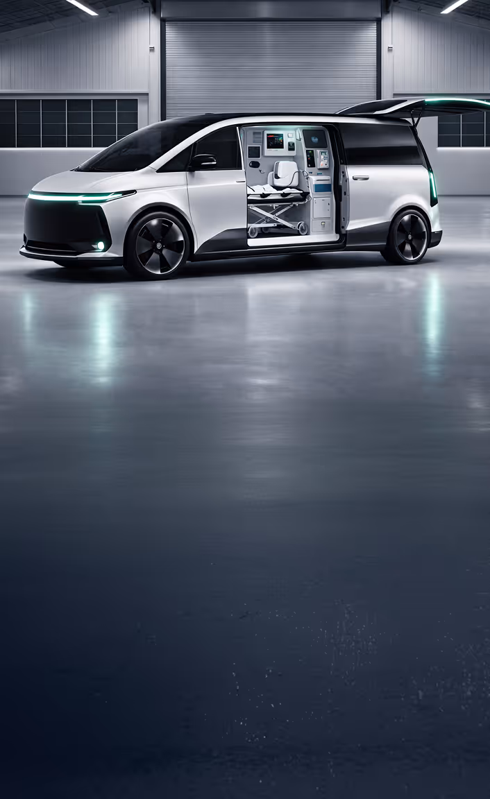 White ambulance van with side and rear doors open showing medical equipment and a stretcher inside.