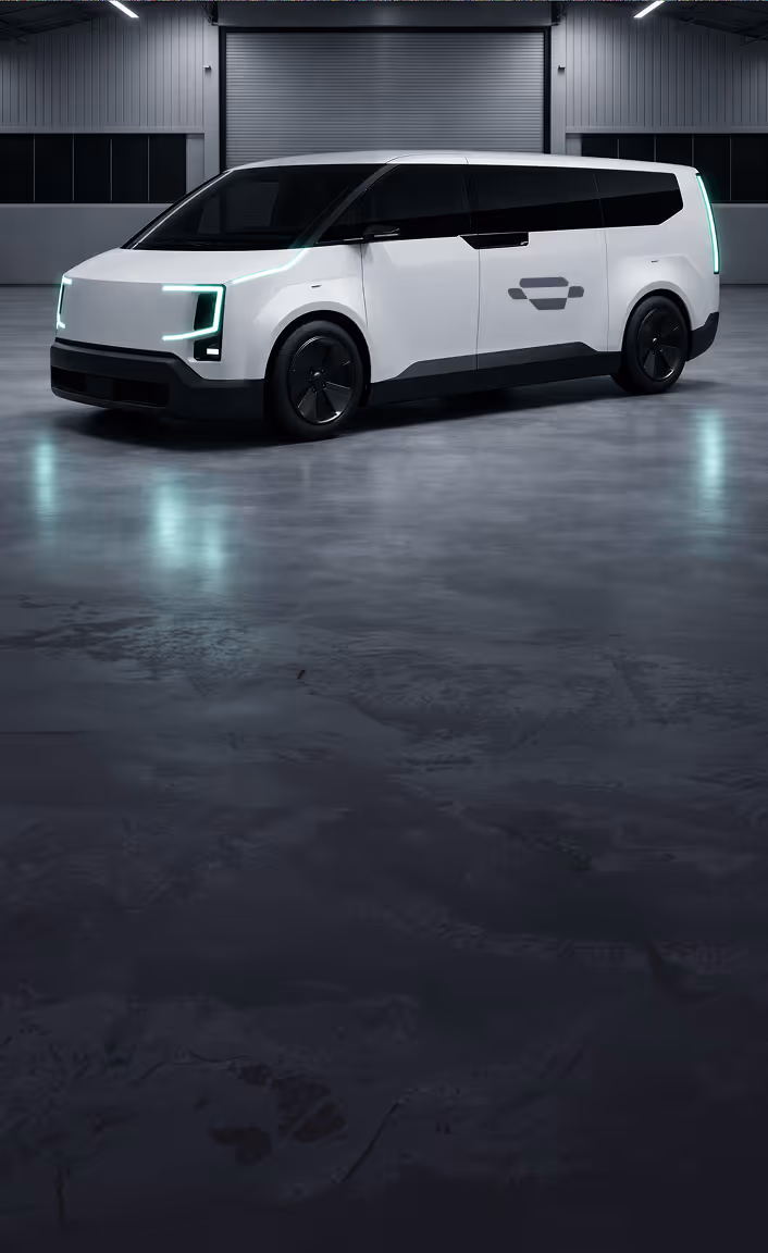 Silver ambulance with side and rear doors open showing medical equipment and stretcher inside, parked in a large indoor space.