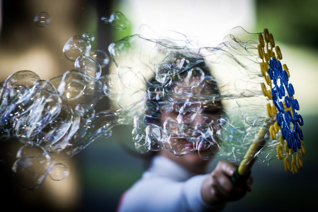 Bubble artist creating a giant bubble at an outdoor event