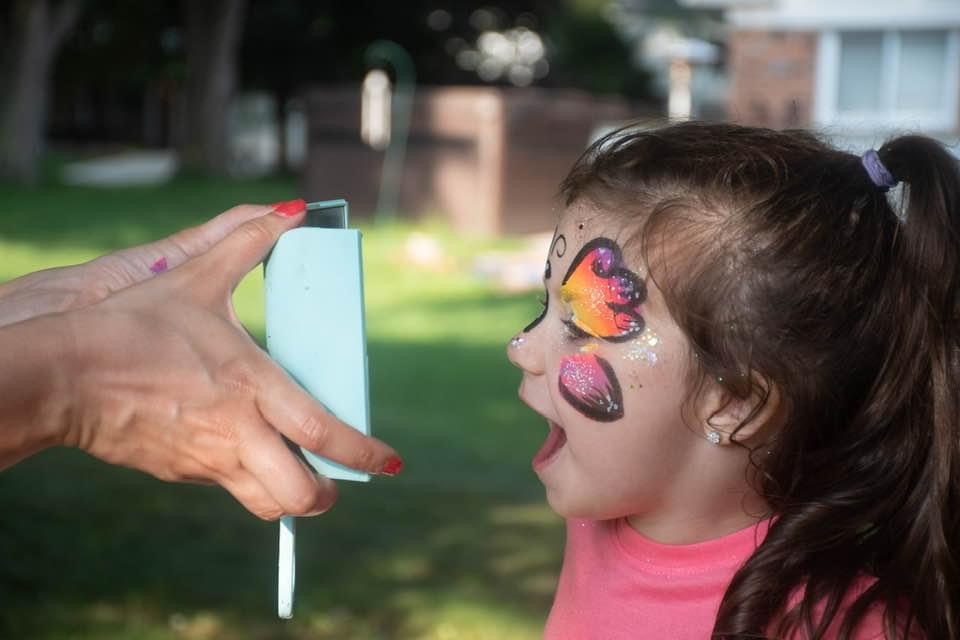 Professional face painter at work on a child at a party