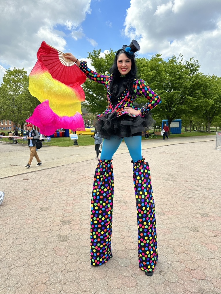 Custom-costumed stilt walker engaging with guests