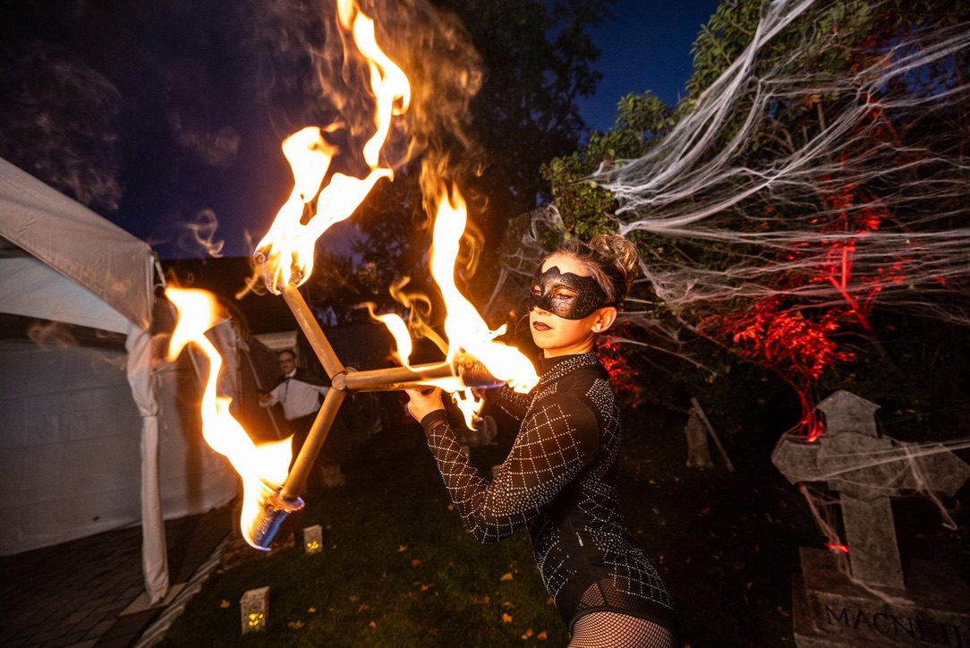 Fire performer with flame props at an outdoor event