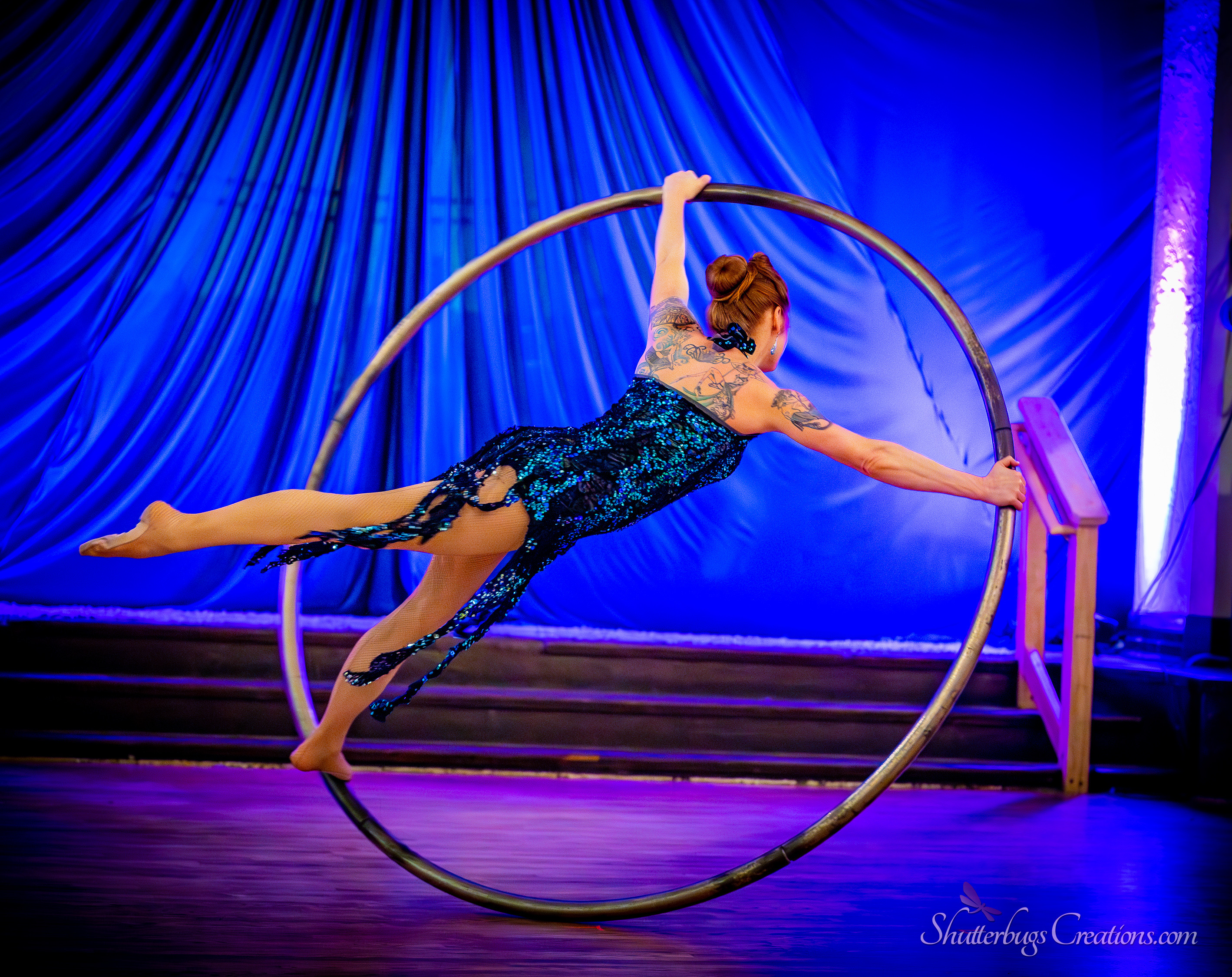 Cyr wheel performer spinning inside a large metal ring at a gala