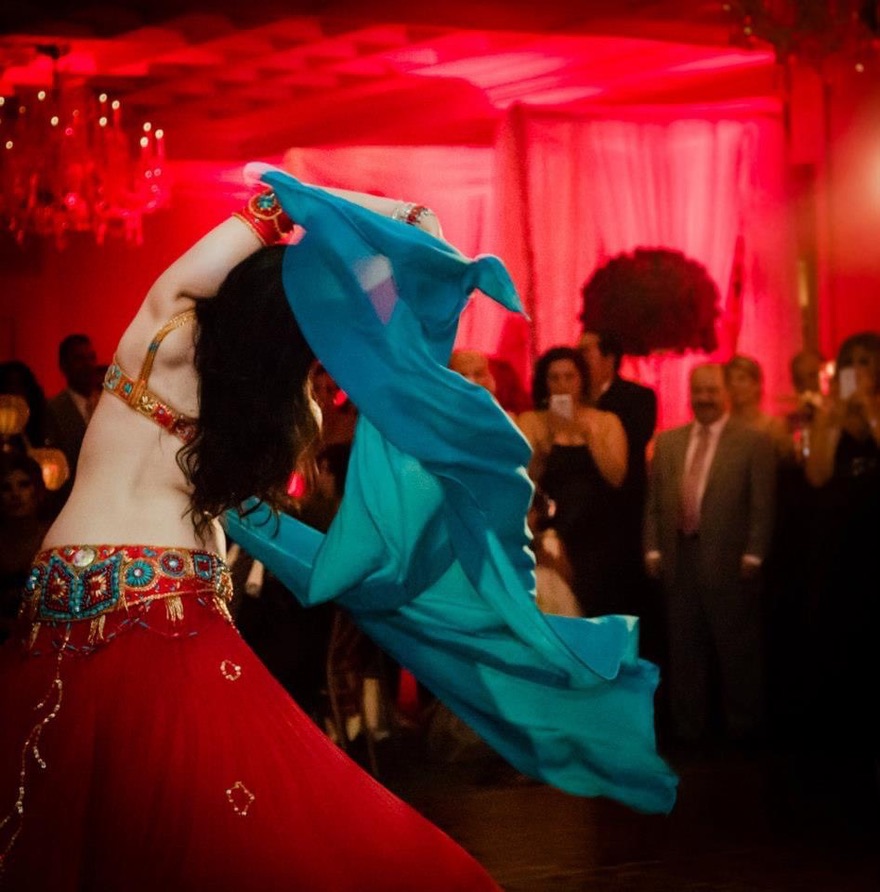 Belly dancer engaging guests with finger cymbals at a DC event