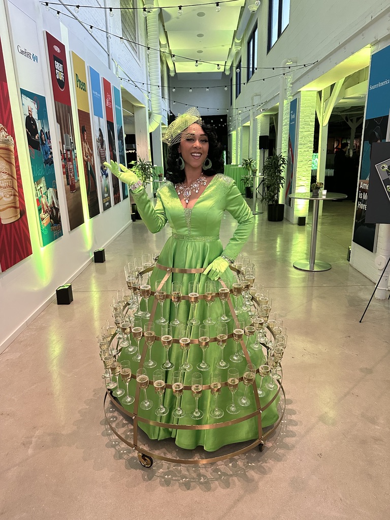 Champagne skirt performer serving drinks in oversized gown