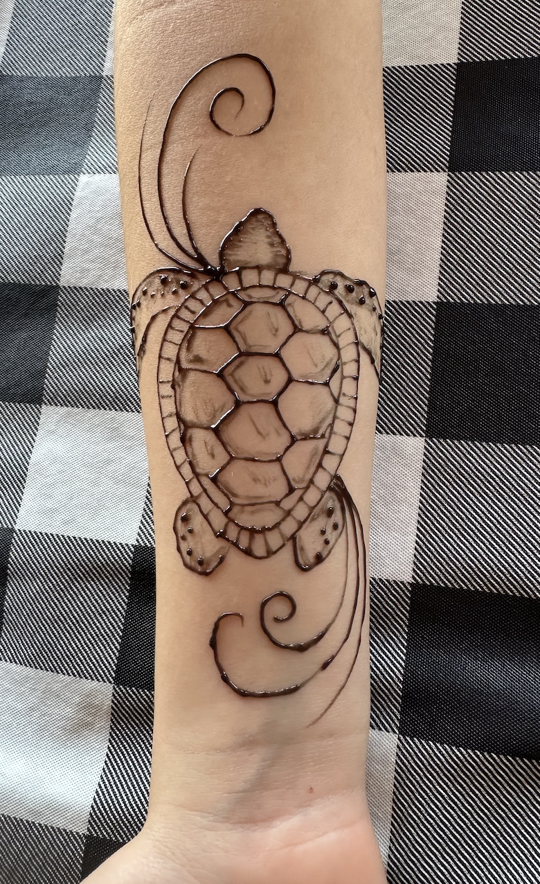Detailed henna design on a guest's hand at a wedding