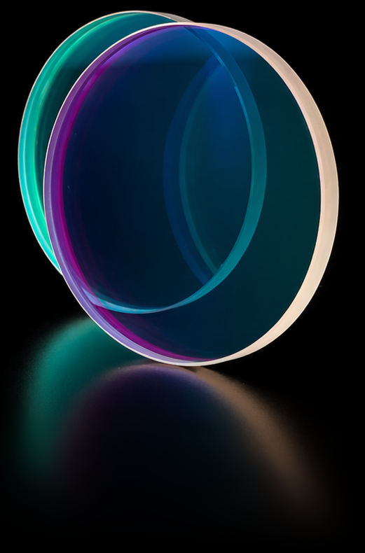 Two circular unmounted band pass optical filters overlapping on a reflective black surface, one showing a teal and cyan interference coating and the other a deep blue and purple coating, with colorful reflections beneath.