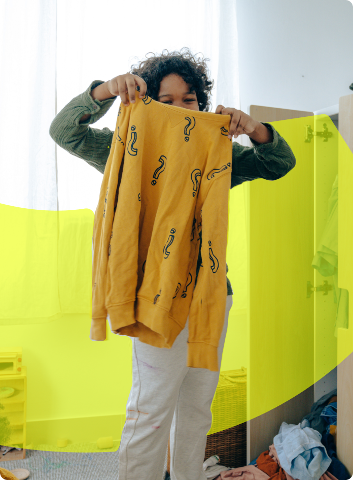 Child Holding Up Old Sweater
