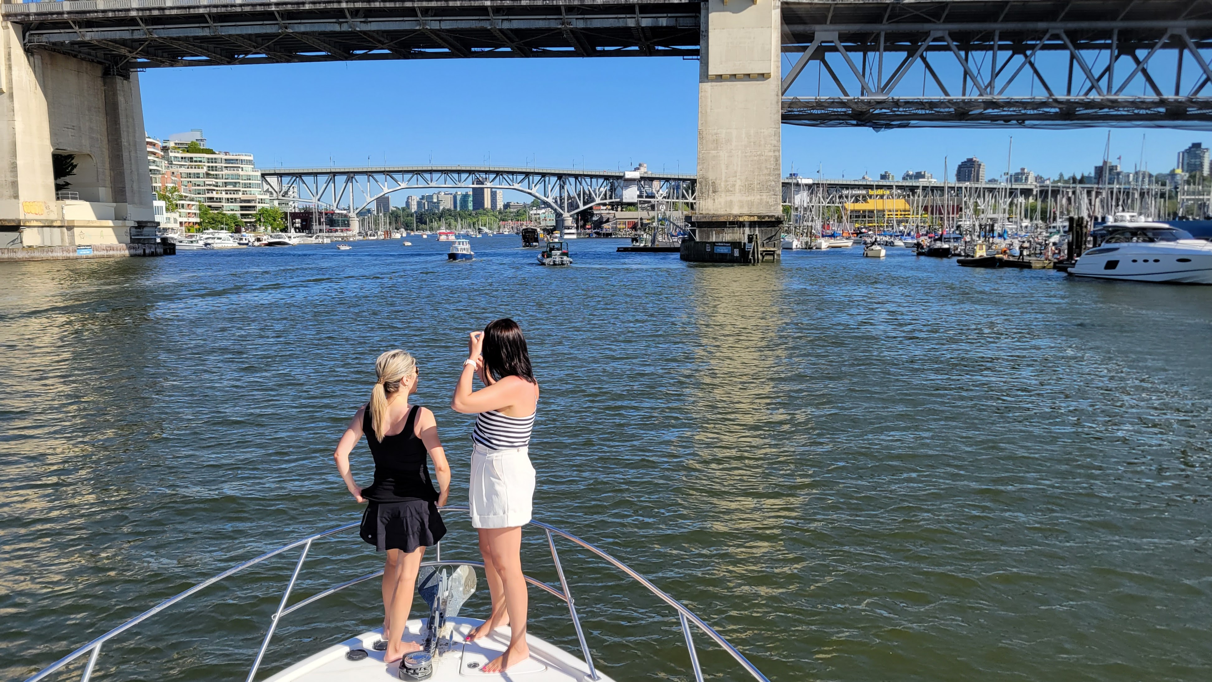 A vibrant park located by the waterfront, filled with families enjoying picnics and children playing under the sun.