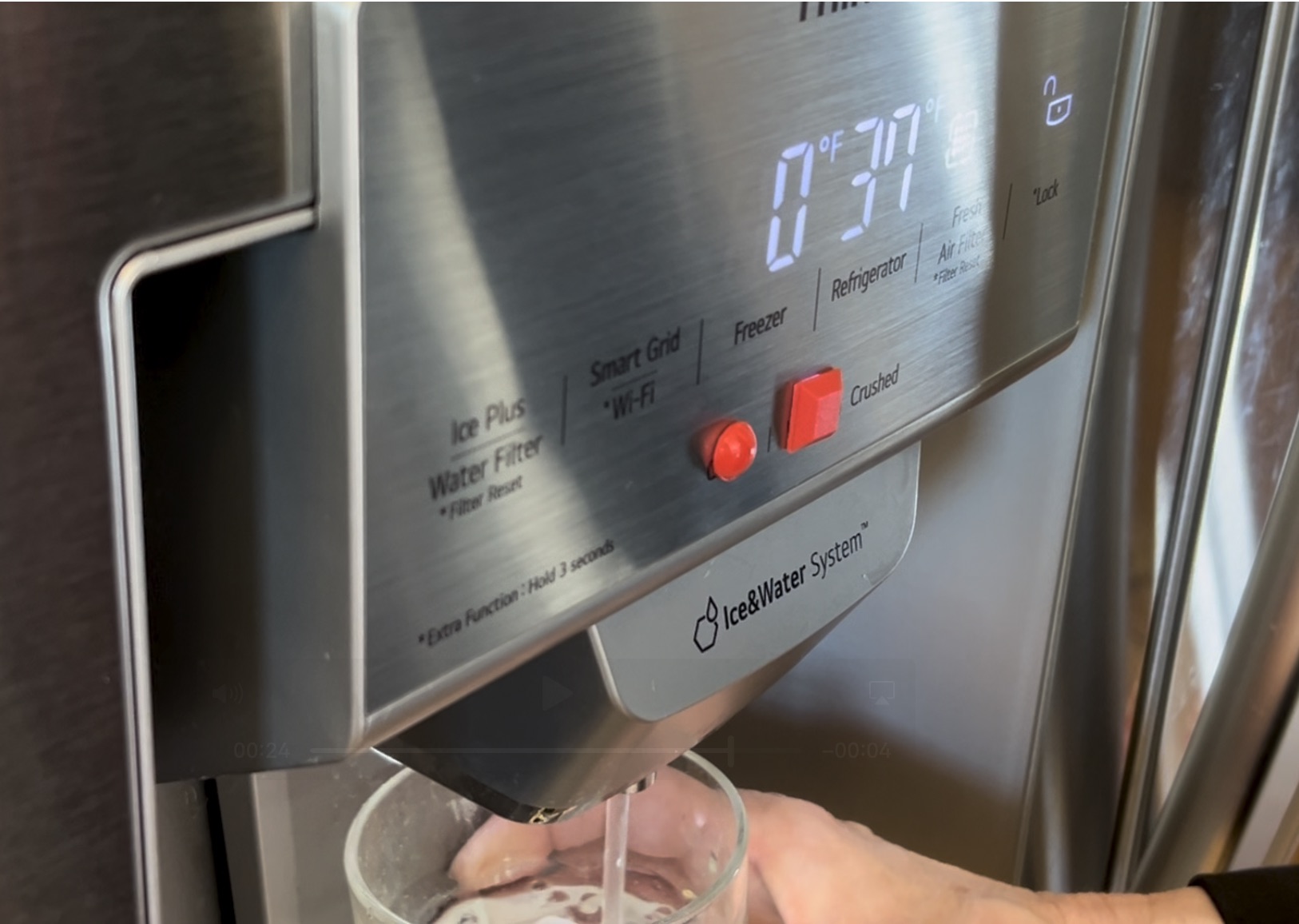 The controls on a fridge with red 3d dots on the water and ice buttons so they can be identified by touch