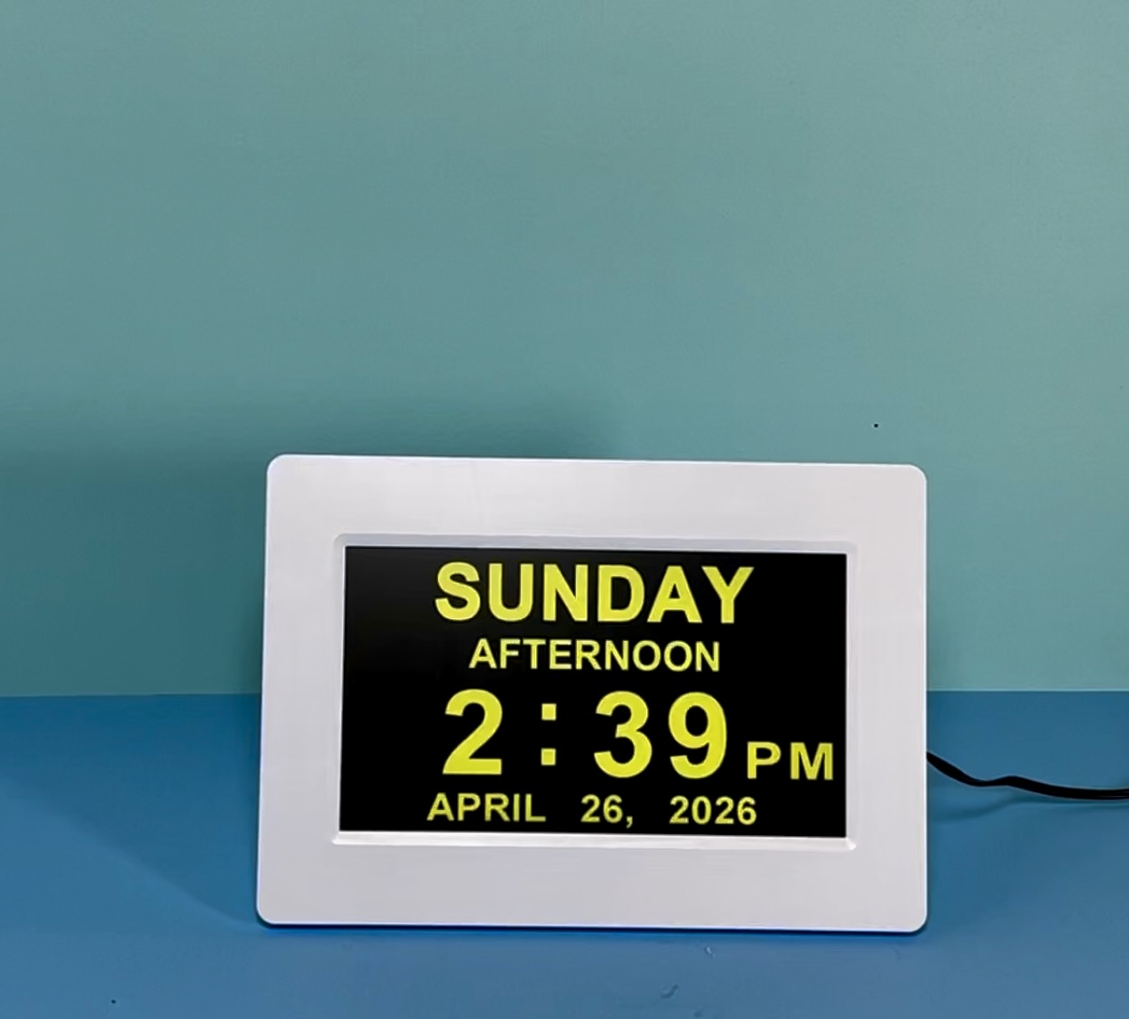 A digital day and time clock displaying Sunday afternoon on a blue surface.