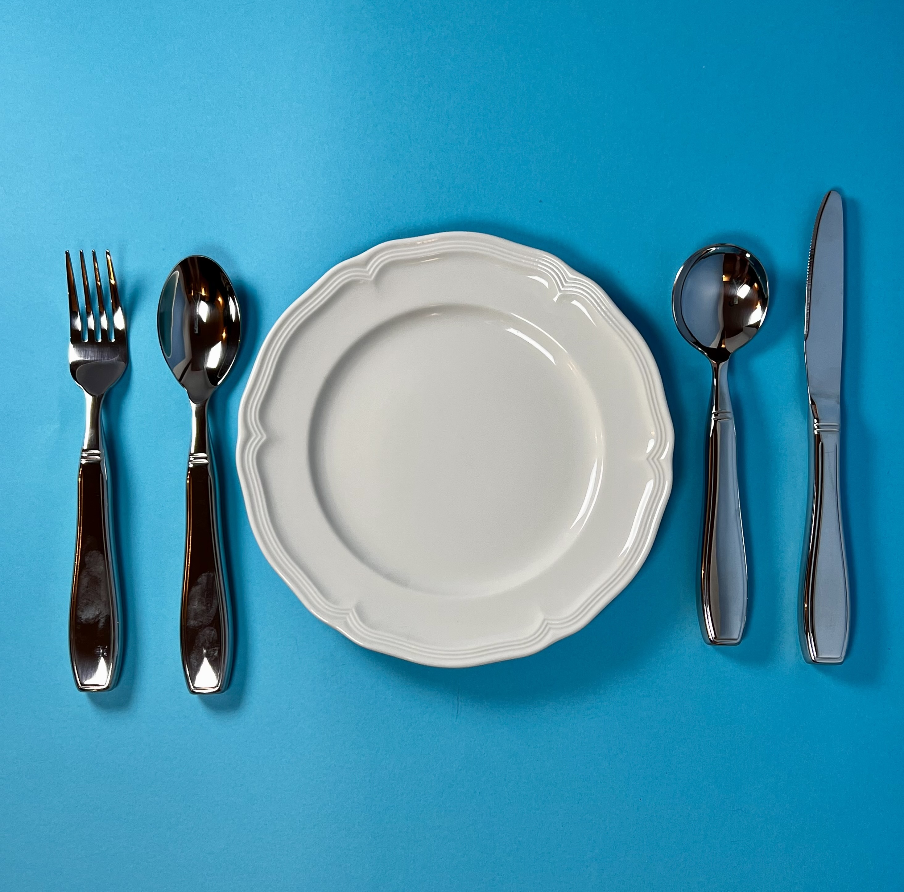 a plate surrounded by weighted silverware for tremor
