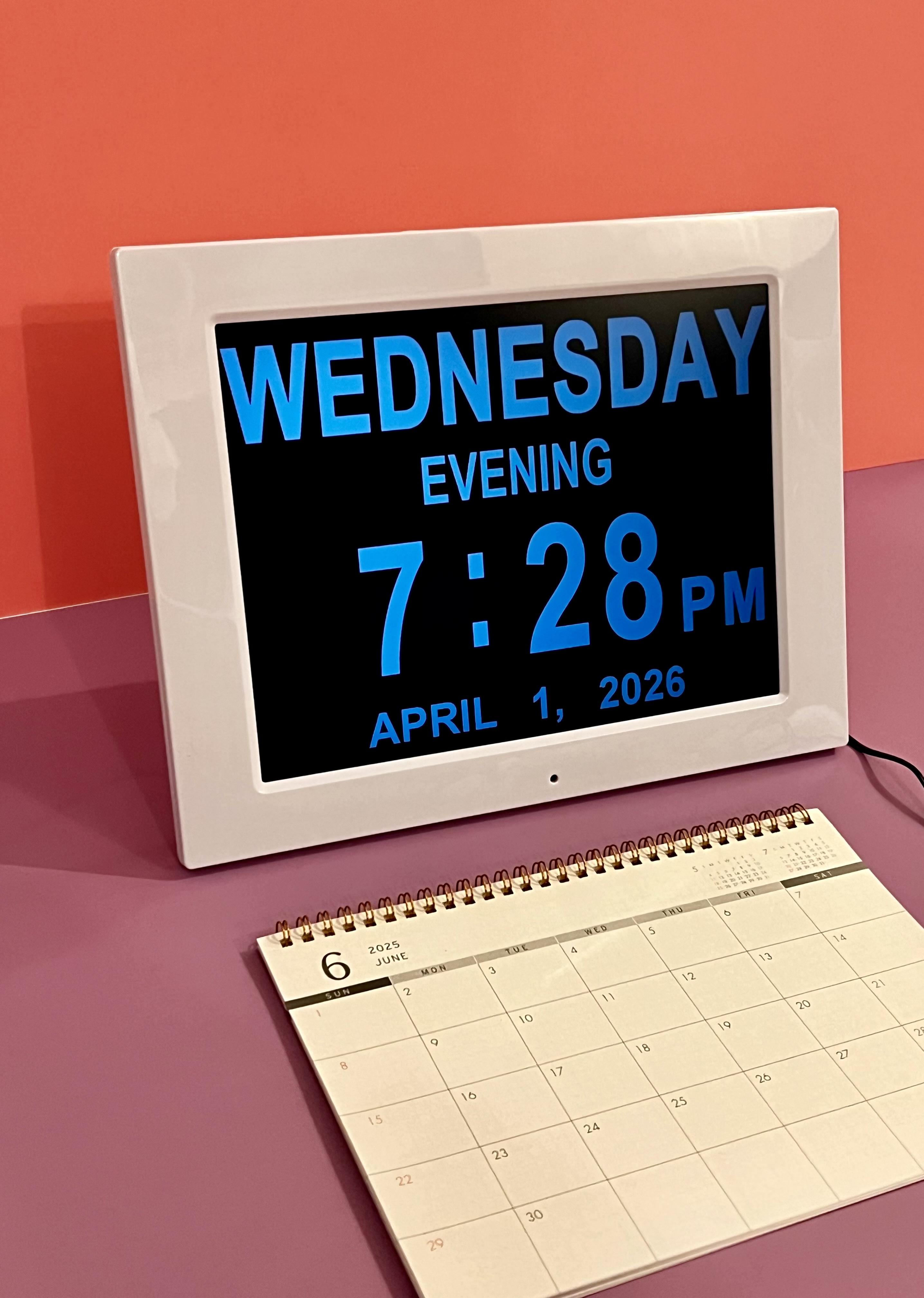 A digital day and time clock displayed above a medication tracking sheet.