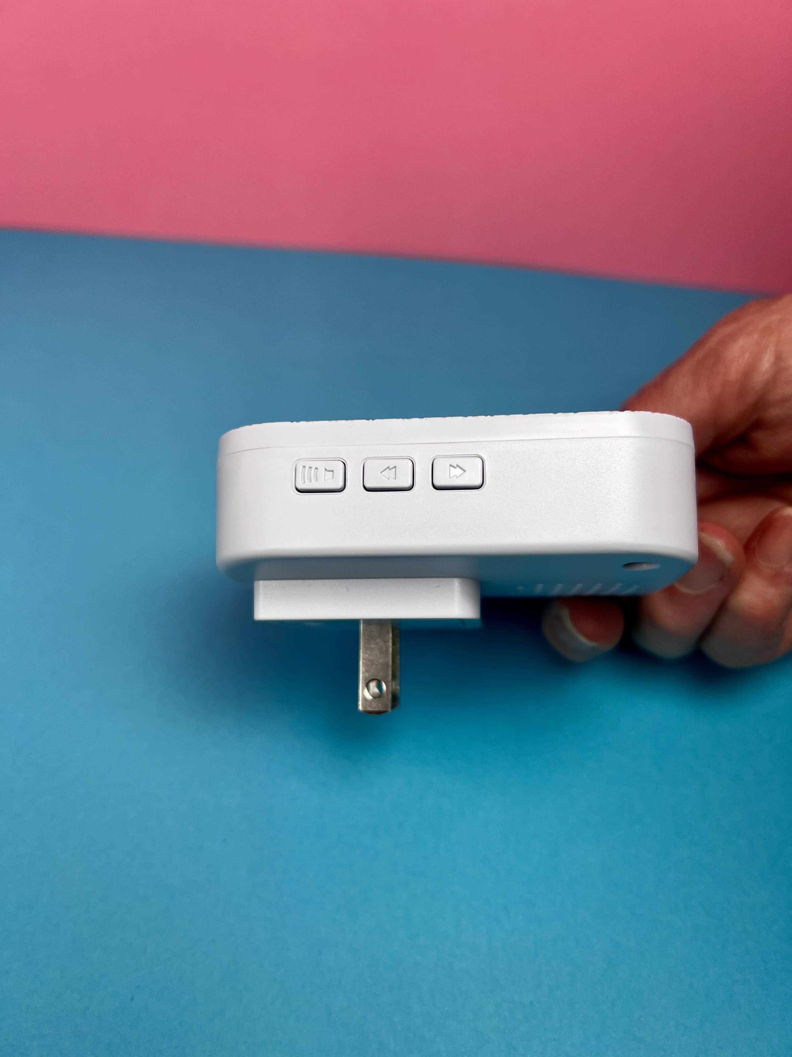 Side view of the white plug-in caregiver alert sounder with volume and play button.