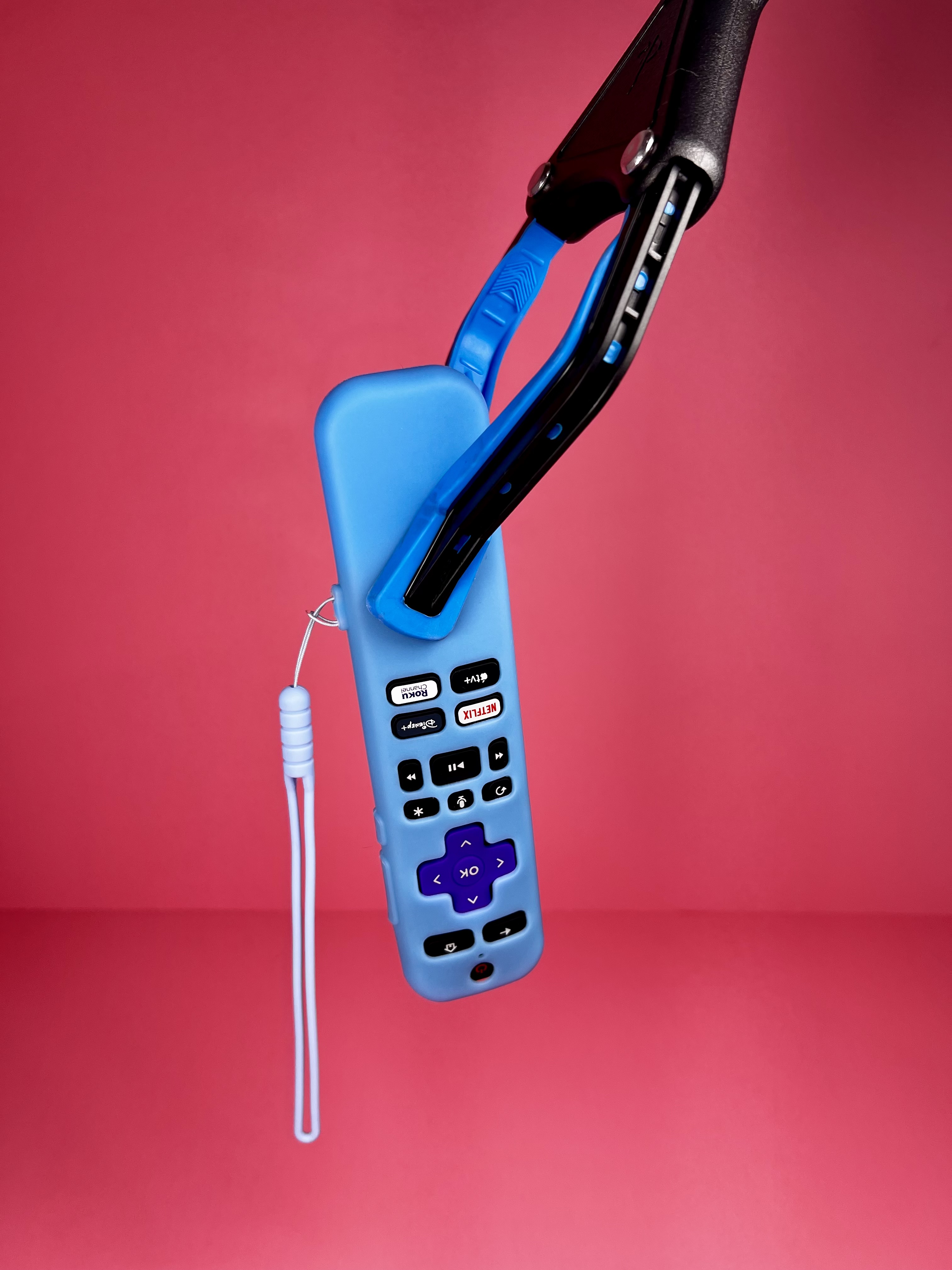 Extended grabber tool picking up a remote control.
